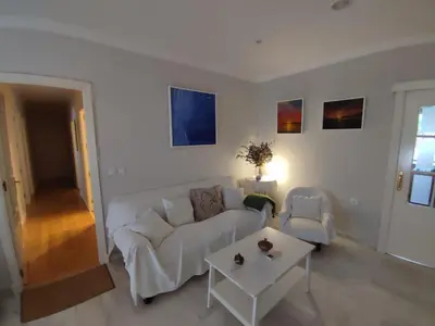 a living room with a white couch and a table at EL RETIRO in Sanlúcar de Barrameda