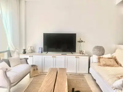 a living room with a couch and a flat screen tv at Casita Playa Conil in Conil de la Frontera