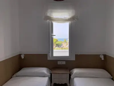 two twin beds in a room with a window at Casita Playa Conil in Conil de la Frontera