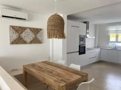 a kitchen and dining room with a wooden table at Casita Playa Conil in Conil de la Frontera