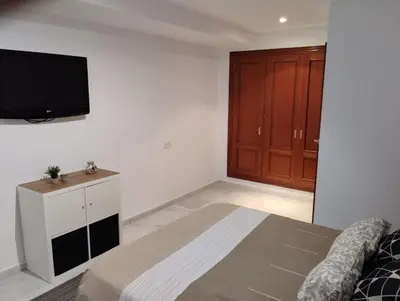 a bedroom with a bed and a tv on a wall at Villa Lago Golf, 300m construidos in Jerez de la Frontera