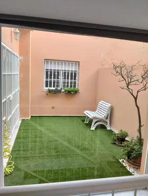 a balcony with a green yard with a bench at Villa Lago Golf, 300m construidos in Jerez de la Frontera