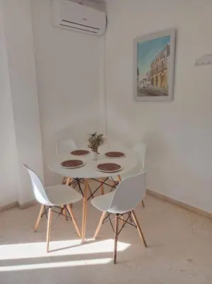 a white table and chairs in a white room at Banda playa 82, en pleno corazón de Sanlucar in Sanlúcar de Barrameda