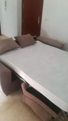 a bed in a room with a white mattress at Banda playa 82, en pleno corazón de Sanlucar in Sanlúcar de Barrameda