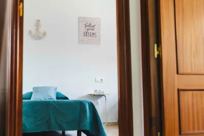 a room with a table and a chair with a green sheet at Casa SOL y MAR junto a la PLAYA in Sanlúcar de Barrameda