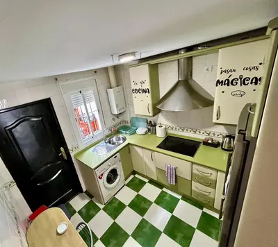 a small kitchen with a green and white checkered floor at Casa SOL y MAR junto a la PLAYA in Sanlúcar de Barrameda