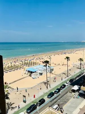 a beach with a lot of people and the ocean at Apartamento a pie de playa. in Cádiz