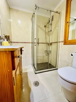 a bathroom with a shower and a toilet and a sink at Apartamento a pie de playa. in Cádiz
