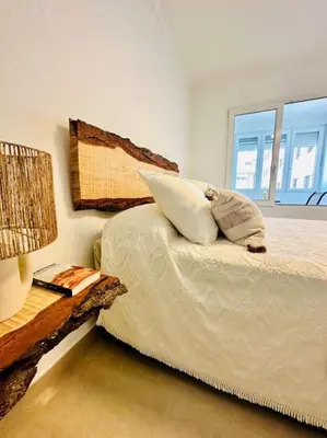 a bedroom with a bed with a pillow and a table at Apartamento a pie de playa. in Cádiz