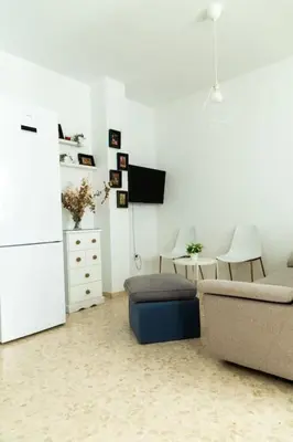 a living room with a couch and a table and a tv at Libertad by Gades Gestión in Cádiz