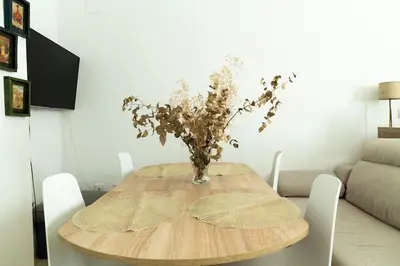 a dining room table with a vase of flowers on it at Libertad by Gades Gestión in Cádiz