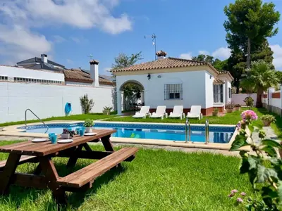 a backyard with a picnic table and a pool at Chalet Manku in Chiclana de la Frontera
