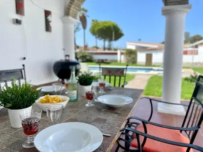 a table with plates of food on a patio at Chalet Manku in Chiclana de la Frontera