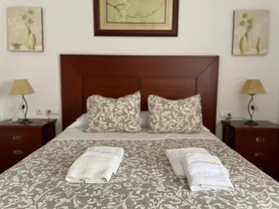 a bedroom with a bed with two white towels on it at Chalet Manku in Chiclana de la Frontera