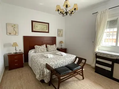 a bedroom with a bed and a chair in it at Chalet Manku in Chiclana de la Frontera