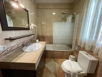 a bathroom with a sink and a toilet and a tub at Chalet Manku in Chiclana de la Frontera