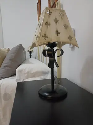 a lamp sitting on a table next to a bed at Piso vacacional en Sanlúcar in Sanlúcar de Barrameda