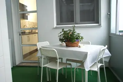 a white table with white chairs and a plant on it at Piso vacacional en Sanlúcar in Sanlúcar de Barrameda