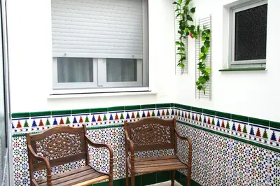two chairs sitting on a screened porch with a window at Piso vacacional en Sanlúcar in Sanlúcar de Barrameda