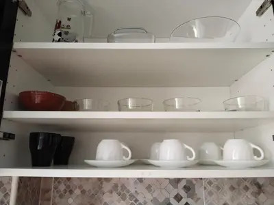 a shelf with bowls and other dishes in a kitchen at Piso vacacional en Sanlúcar in Sanlúcar de Barrameda