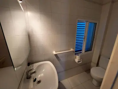 a bathroom with a sink and a toilet and a window at La Almadraba in Novo Sancti Petri