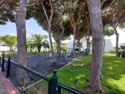 a park with trees and a playground at La Almadraba in Novo Sancti Petri