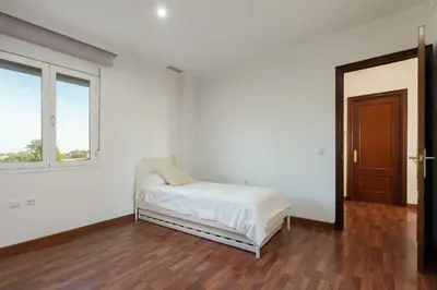 a white room with a bed and a window at Apartoyou - Chalet & Pool in El Puerto de Santa María