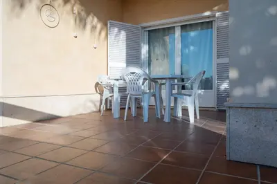 a patio with a table and chairs on a balcony at Apartoyou - Chalet & Pool in El Puerto de Santa María