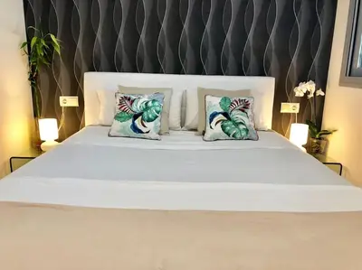a bedroom with a bed with a painting of a beach at Modern Zen Bali in Puerto Real