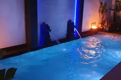 a large swimming pool with blue lights in a room at Modern Zen Bali in Puerto Real