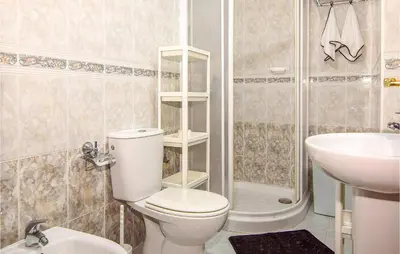 a bathroom with a toilet and a sink and a shower at 1 Bedroom Nice Apartment In Chipiona in Chipiona