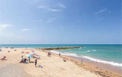 a group of people on a beach near the ocean at 1 Bedroom Nice Apartment In Chipiona in Chipiona