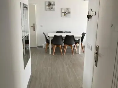 a dining room with a white table and black chairs at Villa El Lagar in Novo Sancti Petri