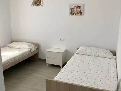 a room with two beds and a night stand at Villa El Lagar in Novo Sancti Petri