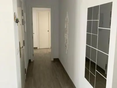 a hallway with white walls and wooden floors and a white door at Villa El Lagar in Novo Sancti Petri