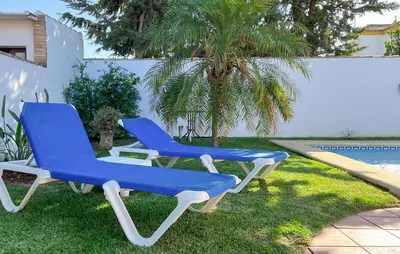 two blue and white chairs sitting on the grass at Gorgeous Home In Chiclana De La Fronter in Chiclana de la Frontera