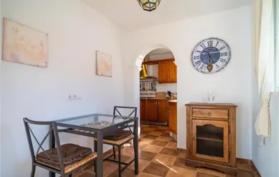 a dining room with a table and a clock on the wall at Gorgeous Home In Chiclana De La Fronter in Chiclana de la Frontera