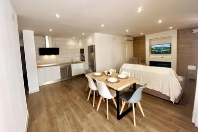 a kitchen and dining room with a table and chairs at Fernando de Magallanes 15, Bajo en segunda línea de playa in Sanlúcar de Barrameda