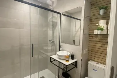 a bathroom with a glass shower and a sink at Fernando de Magallanes 15, Bajo en segunda línea de playa in Sanlúcar de Barrameda