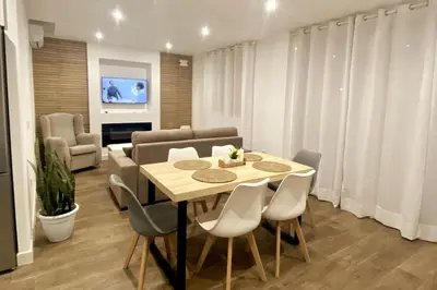 a dining room with a table and chairs at Fernando de Magallanes 15, Bajo en segunda línea de playa in Sanlúcar de Barrameda