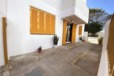 a white building with a window and some plants at Fernando de Magallanes 15, Bajo en segunda línea de playa in Sanlúcar de Barrameda