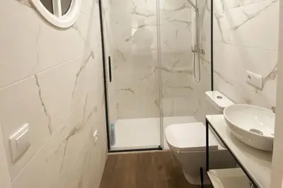 a bathroom with a shower and a toilet and a sink at Fernando de Magallanes 15, Bajo en segunda línea de playa in Sanlúcar de Barrameda