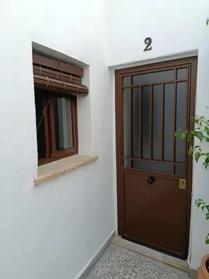 a door and a window in a white building at Apartamentos Casa Vicario in Jerez de la Frontera