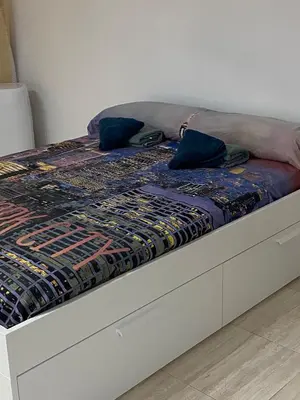 a bed in a room with a bedskirtspectspectspects at Apartamento EleMia in Sanlúcar de Barrameda