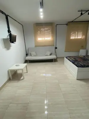 a room with a bed and a table in it at Apartamento EleMia in Sanlúcar de Barrameda