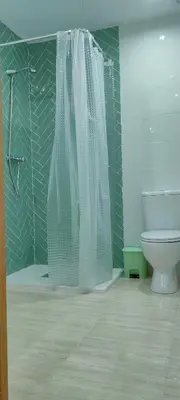 a bathroom with a shower curtain and a toilet at Apartamento EleMia in Sanlúcar de Barrameda