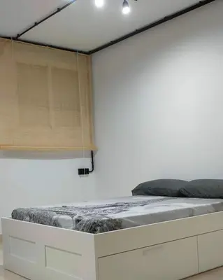 a bed in a room with a white wall at Apartamento EleMia in Sanlúcar de Barrameda