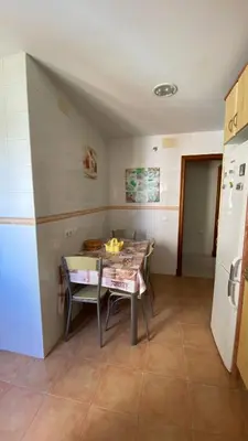 a small kitchen with a table and a refrigerator at Puerto Barrio Alto in El Puerto de Santa María
