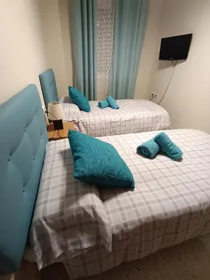 two beds in a room with blue pillows on them at Puerto Barrio Alto in El Puerto de Santa María