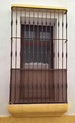 a window with a iron fence on a building at Loft del Capataz in San Fernando